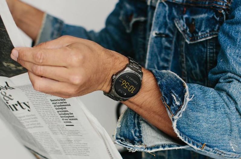 Fossil Explorist HR Smartwatch beim Zeitungslesen am Handgelenk