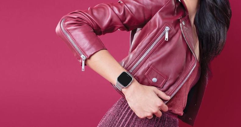 Frau in Bewegung mit Fitbit Versa Smartwatch am Handgelenk