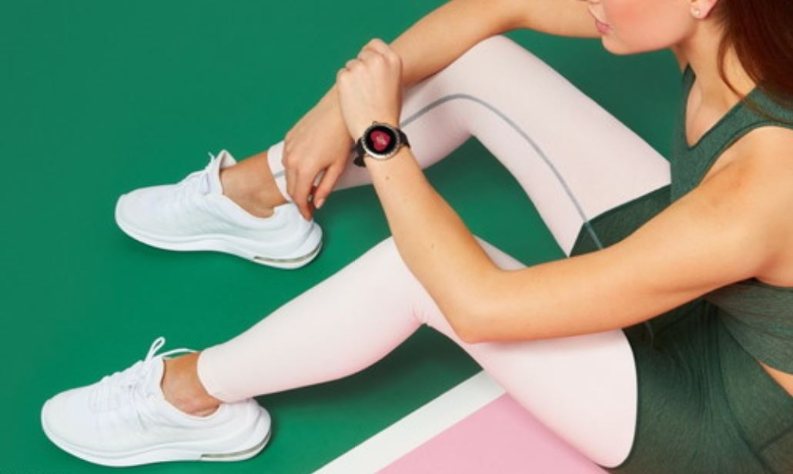 Frau sitzend mit Sportkleidung und Kate Spade Scallop 2 Smartwatch am Handgelenk