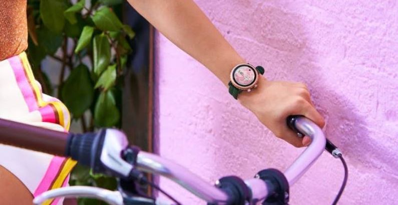 Dame mit Kate Spade New York Sport Smartwatch am Handgelenk auf Fahrrad